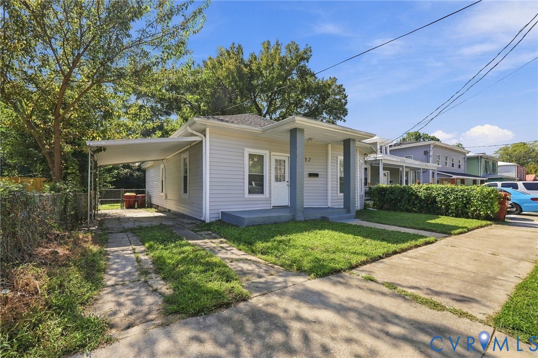 Siding exterior with a covered front porch, carport, and concrete driveway