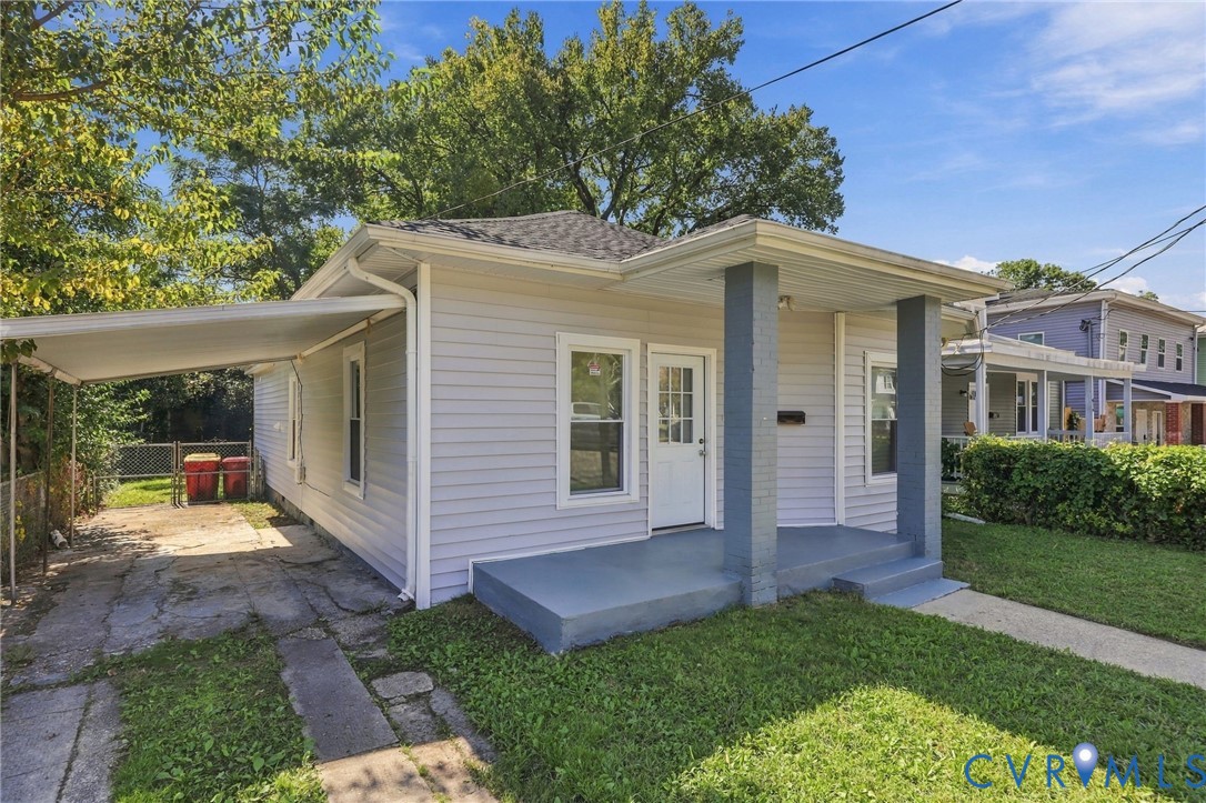 Light-colored siding exterior with a covered front porch featuring two square columns and a concrete walkway