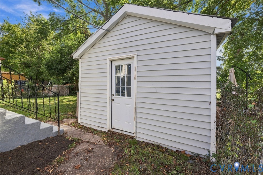 Detached storage shed with horizontal siding and a paneled door