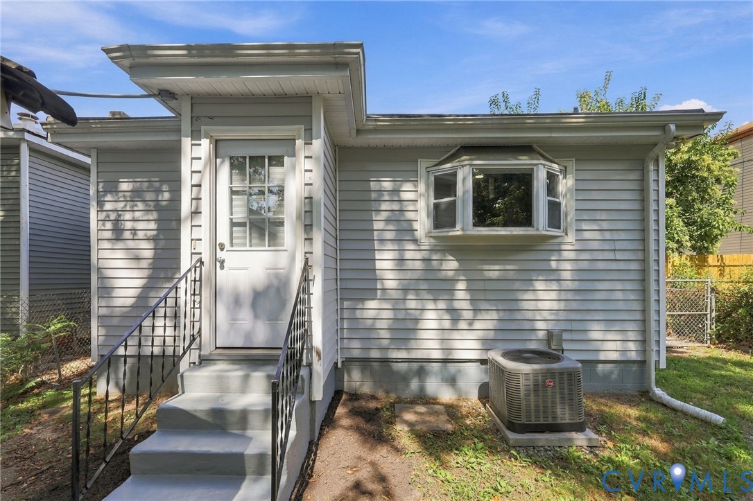 Exterior with horizontal siding, a bay window, and a white entry door