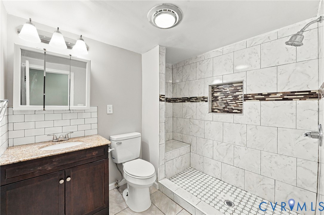 Walk-in shower with tiled walls, integrated niche, and built-in bench
