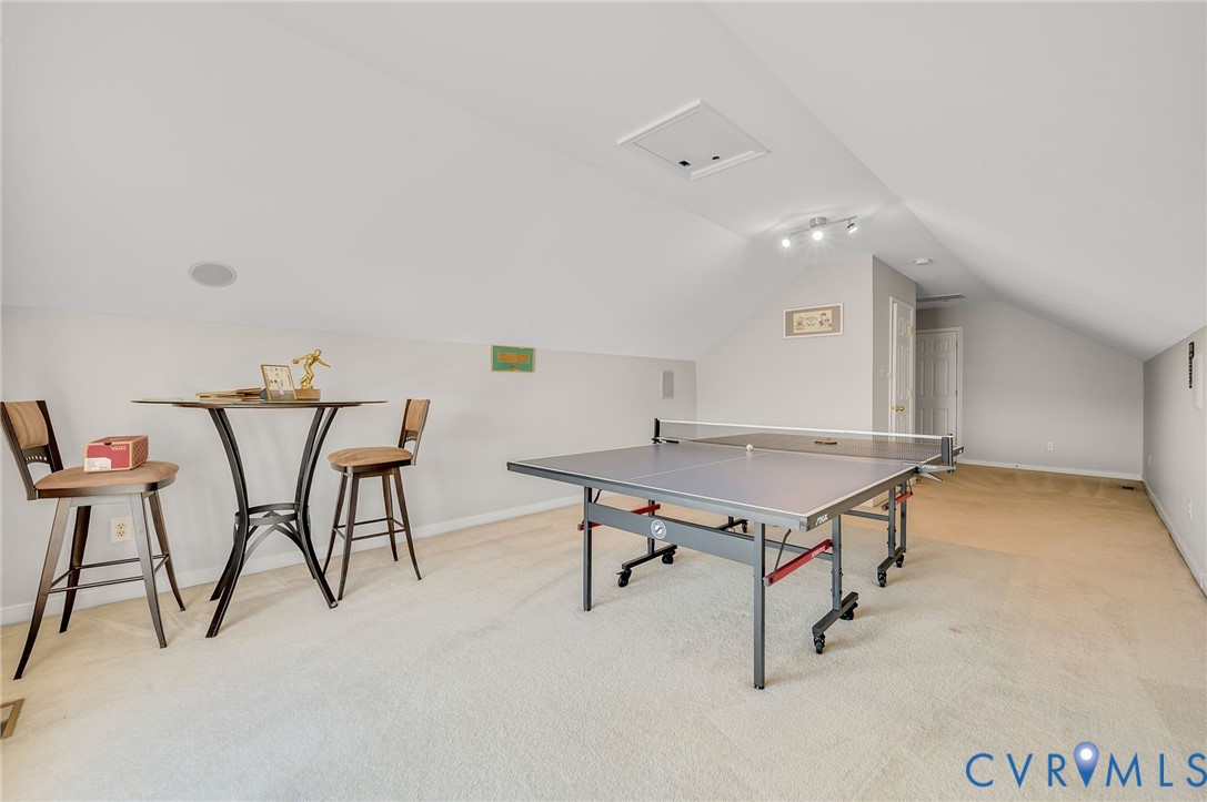 Spacious bonus room featuring sloped ceilings, recessed speaker, and track lighting