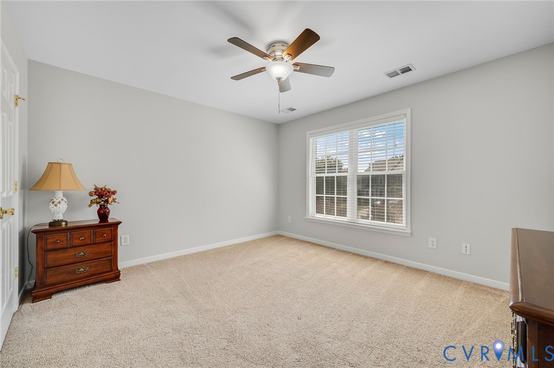 Carpeted flooring, a ceiling fan with integrated lighting, window with blinds, and white trim molding