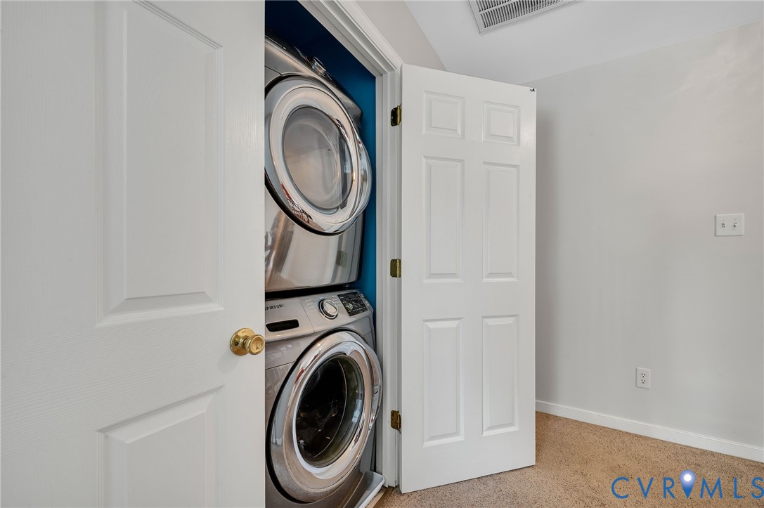 Dedicated laundry area featuring a stackable washer and dryer within a built-in closet