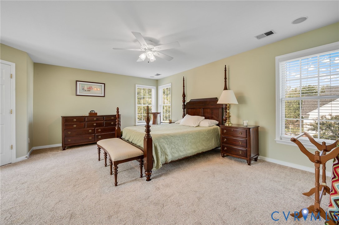 Plush carpeted flooring, multiple windows, recessed lighting, and a ceiling fan