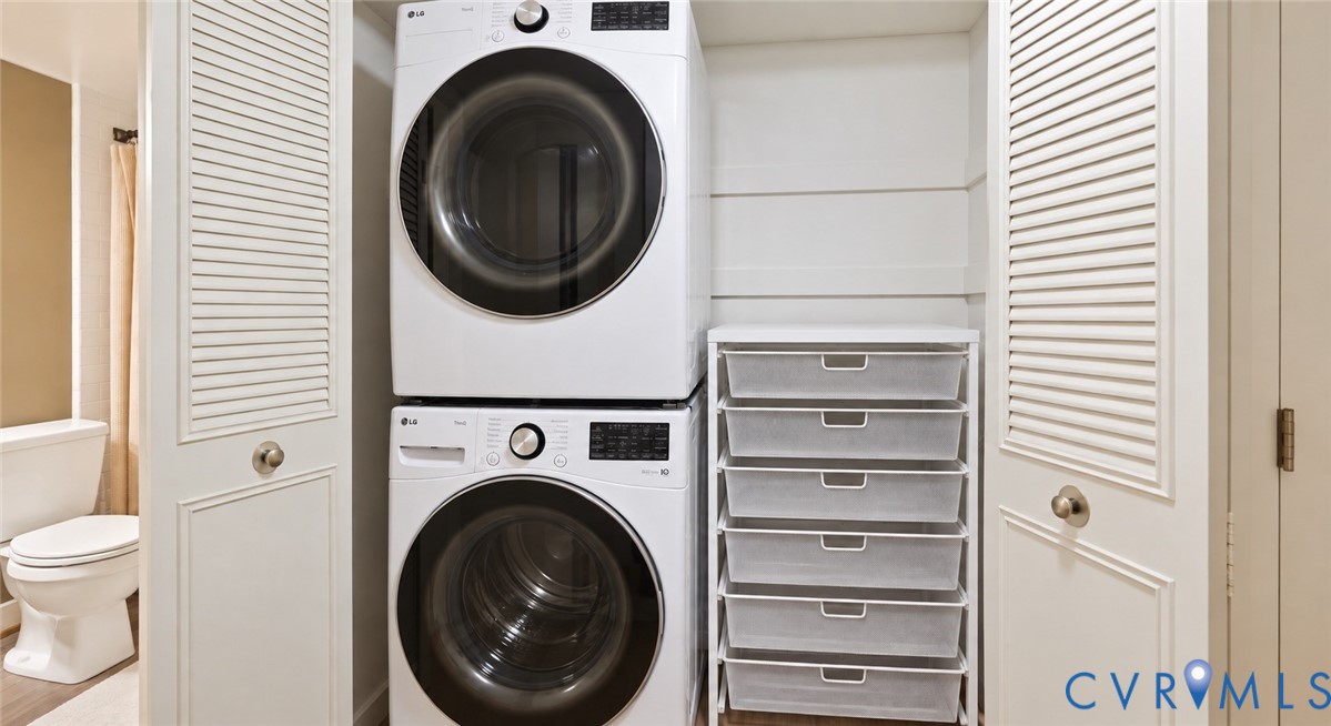 Stacked washer and dryer units, white louvered bifold doors, and integrated wire drawer storage