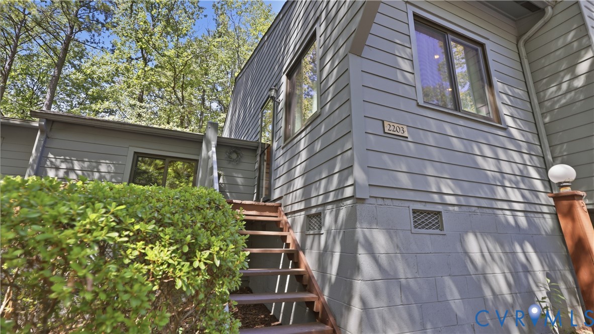 Exterior featuring horizontal siding, multi-pane windows, and a prominent entry staircase Exterior featuring horizontal siding, multi-pane windows, and a prominent entry staircase