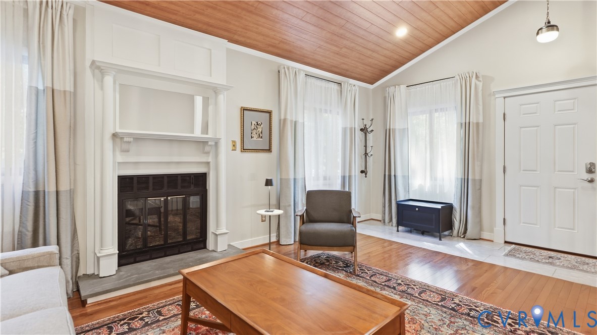 Vaulted wood-paneled ceiling, white paneled door, stone fireplace surround, white fireplace mantel, and wood-finish flooring Vaulted wood-paneled ceiling, white paneled door, stone fireplace surround, white fireplace mantel, and wood-finish flooring