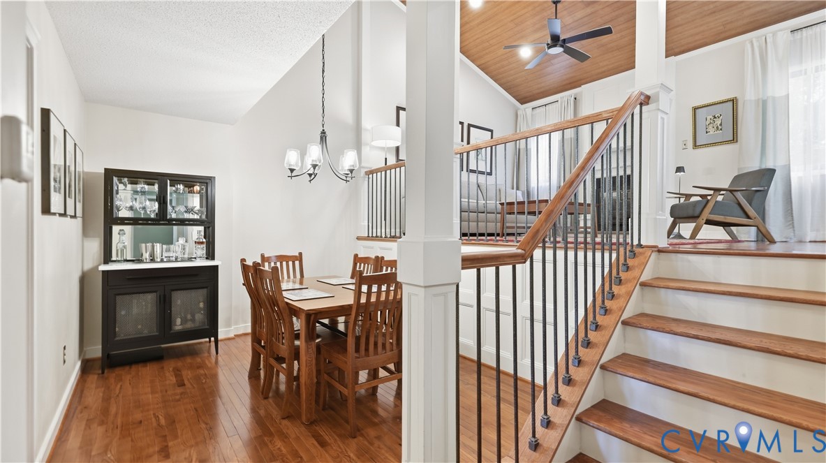 Wood-finish flooring throughout, a vaulted wood-paneled ceiling, and a staircase with wood treads and wrought iron spindles