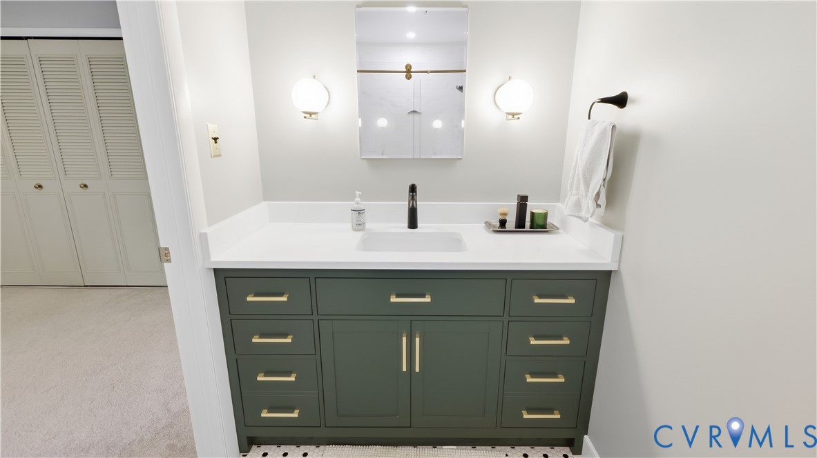 Vanity with a white countertop, rectangular sink, and matte black faucet