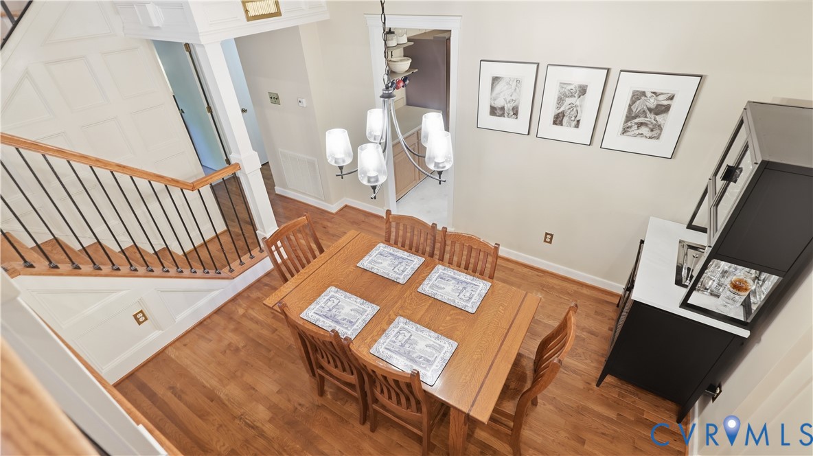 Hardwood flooring throughout, with a white paneled staircase featuring black metal balusters