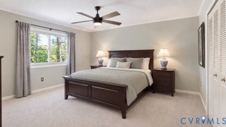 Wall-to-wall carpeting, window with natural scenery, ceiling fan with integrated lighting, and louvered bifold closet doors