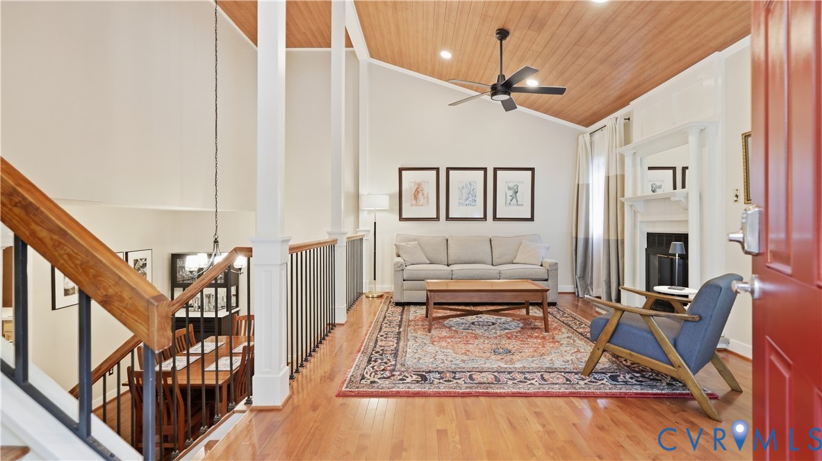 Hardwood flooring throughout, vaulted wood-paneled ceiling, and a prominent white mantelpiece over the fireplace Hardwood flooring throughout, vaulted wood-paneled ceiling, and a prominent white mantelpiece over the fireplace
