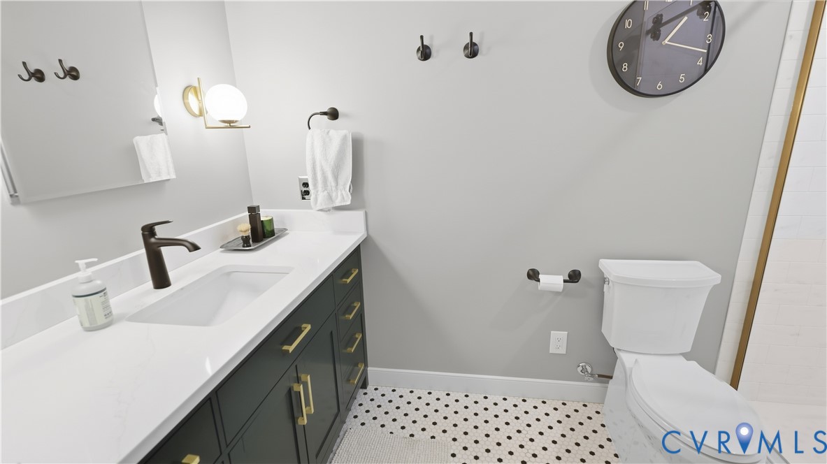White single-basin vanity with a dark finish cabinet and gold-tone hardware