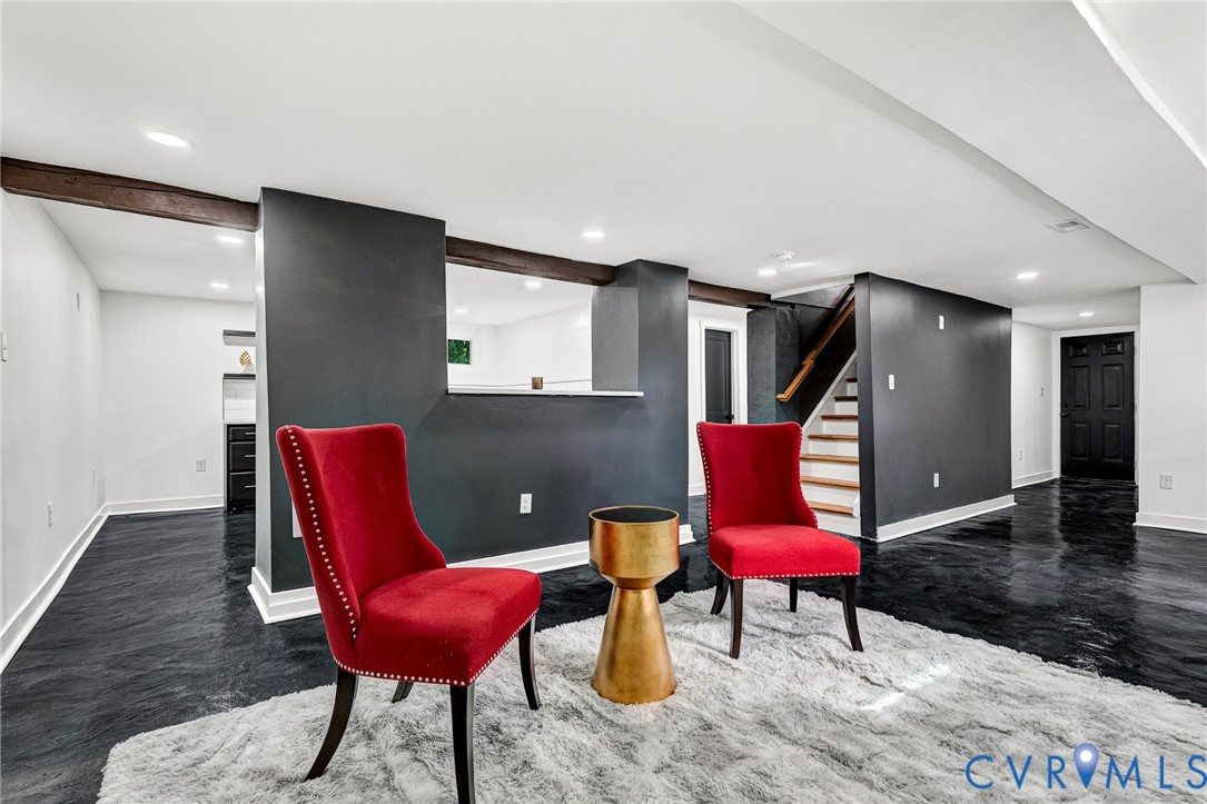 Recessed lighting, wood-finish beams, and dark flooring throughout