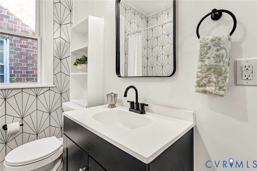 Modern vanity with an integrated white sink and black hardware, complemented by a contemporary framed mirror