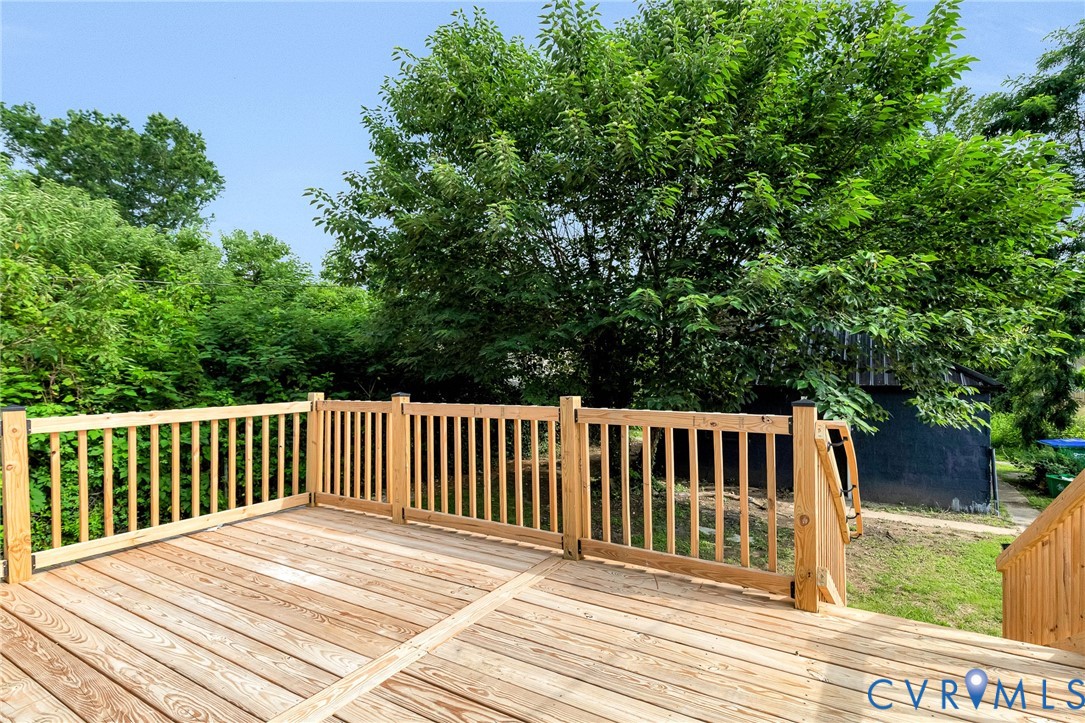 Expansive wood deck with natural wood railing and a gated entry