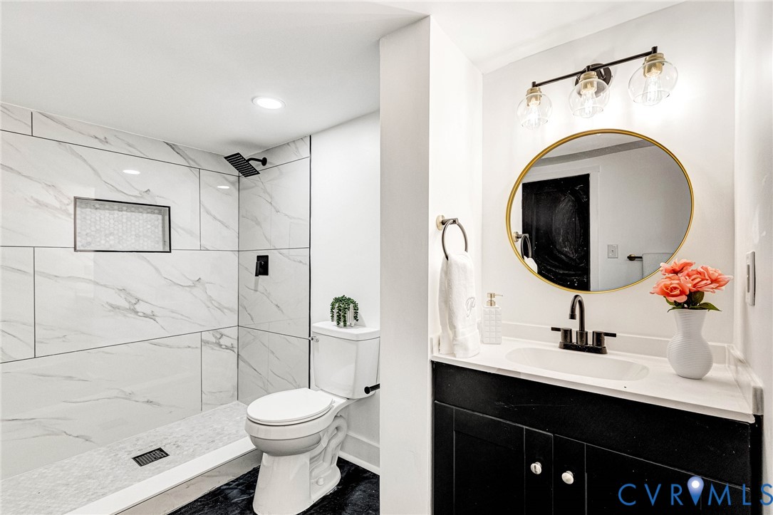 Shower featuring white marble-look tile, a recessed niche, and a matte black rainfall showerhead
