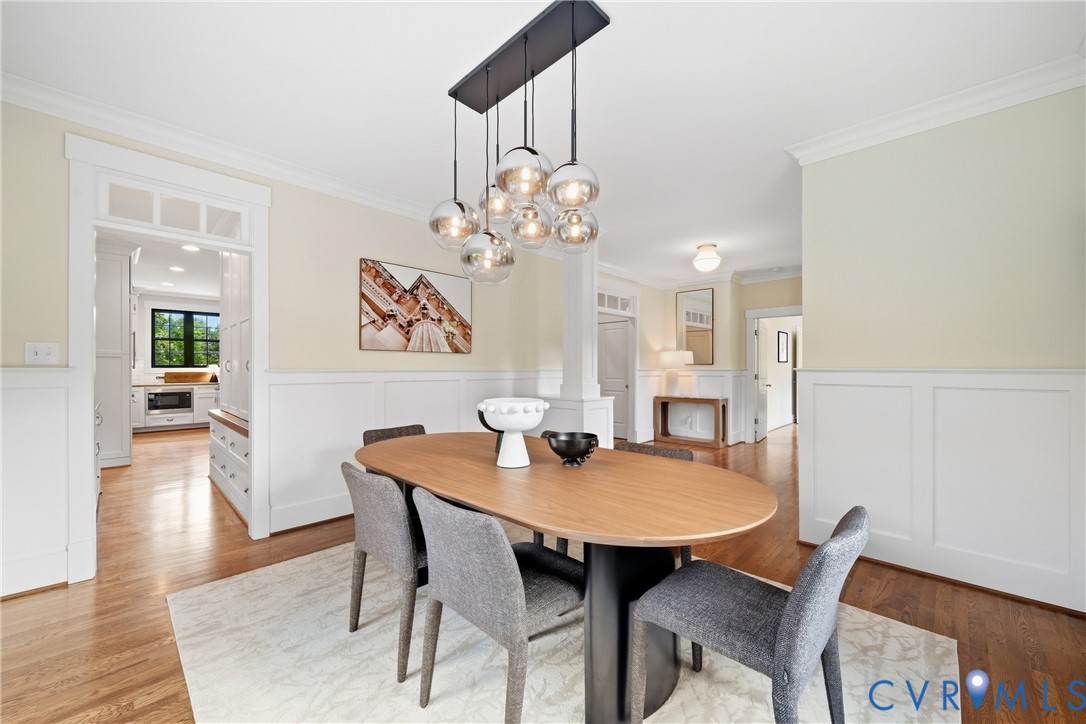 Hardwood flooring throughout, wainscoting details, and a modern chandelier