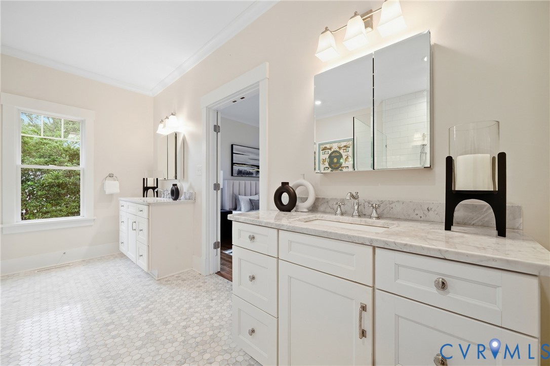 Dual vanity with white cabinetry, stone countertops, and integrated sinks
