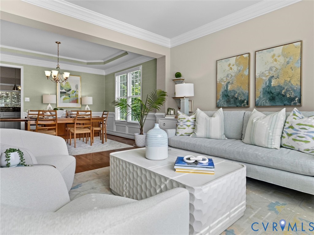 Tray ceiling with crown molding, wood-finish flooring, and window with plantation shutters