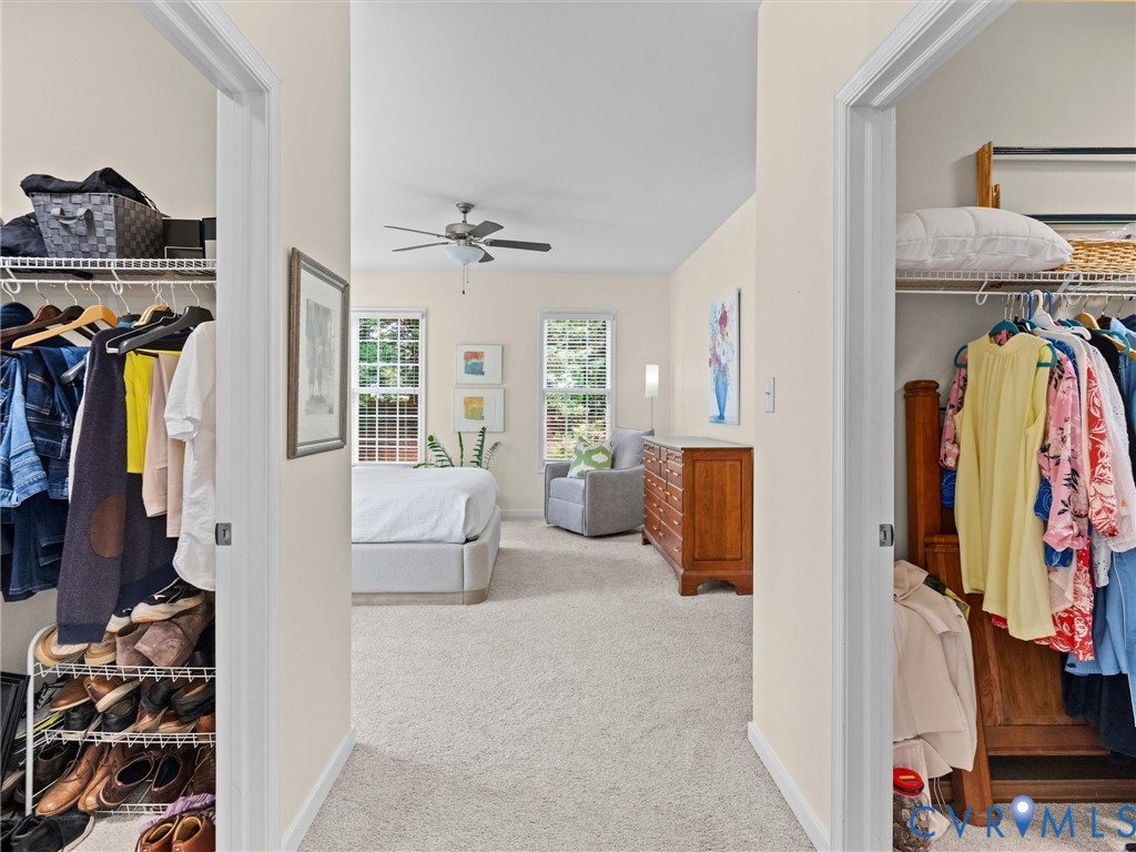 Plush carpet flooring, multiple windows, and a ceiling fan