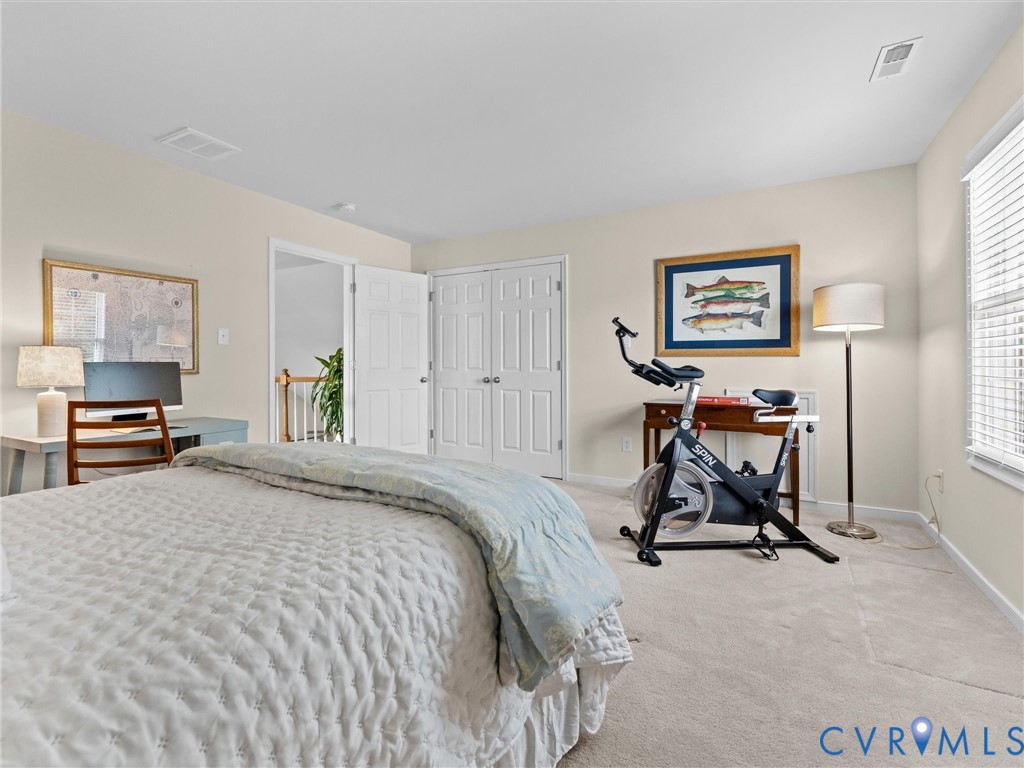 Neutral-toned walls, light-colored carpeting, white trim, and a window with blinds