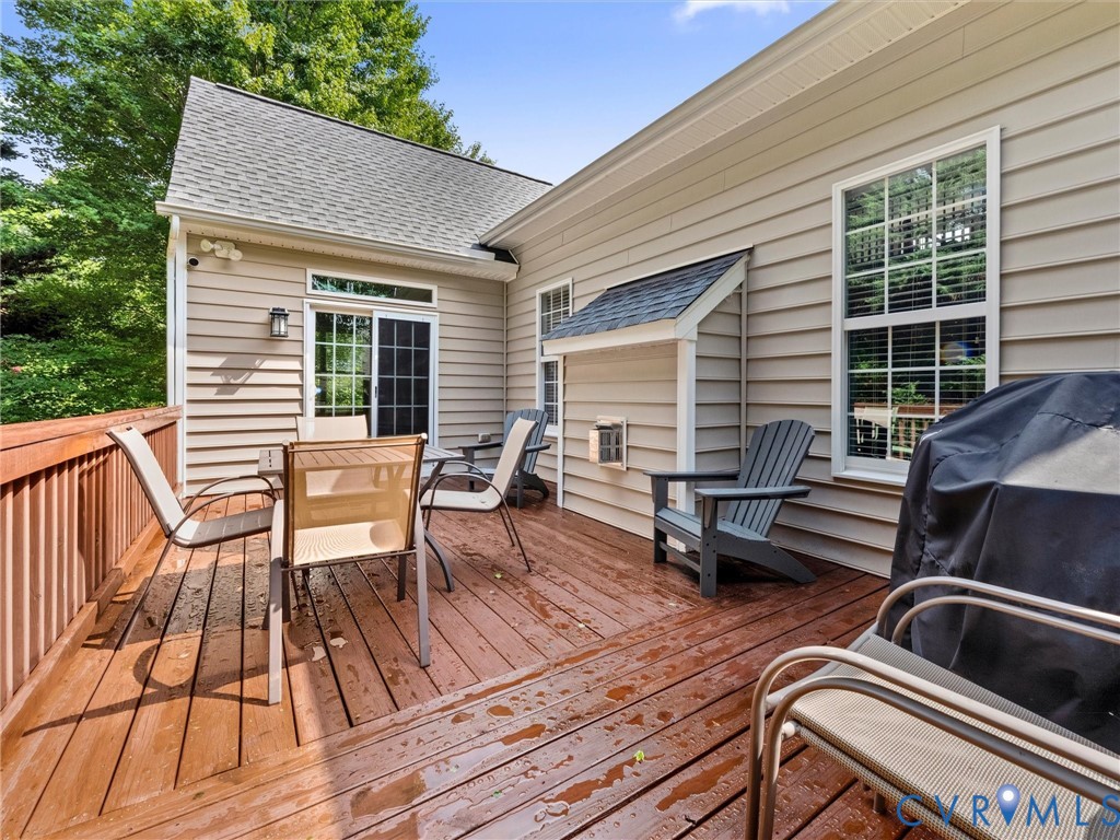 Expansive wood deck with a privacy railing, siding exterior, and sliding glass door access