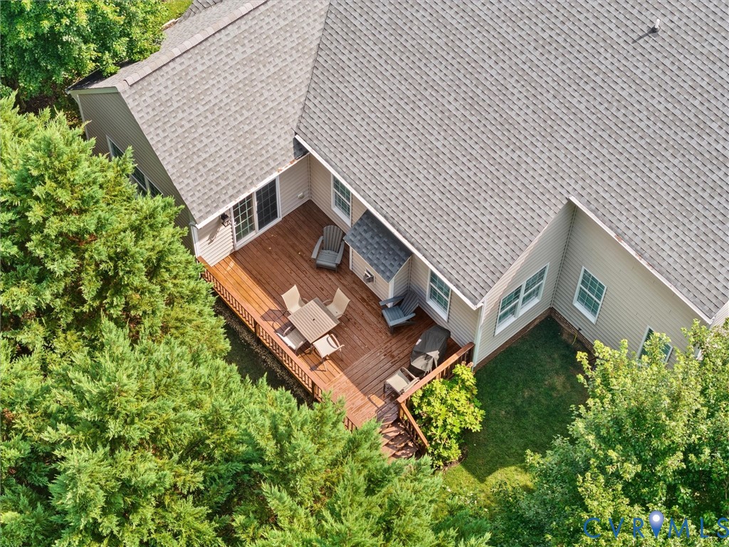 Expansive wood-finish deck with railing and stairs, offering multiple access points from the home
