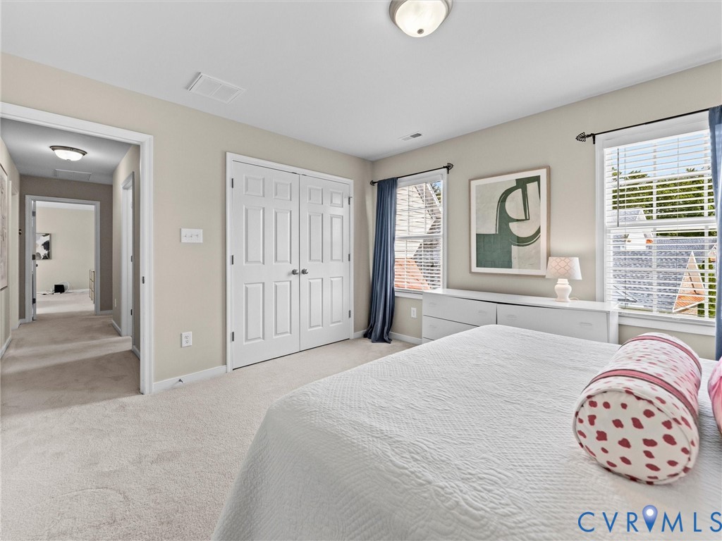 Plush carpeting, dual windows, and ceiling-mounted lighting