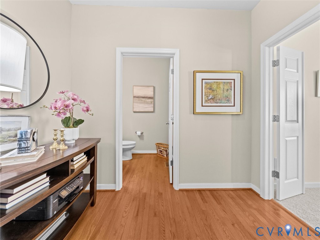 Hardwood flooring throughout, white baseboards, and neutral wall paint