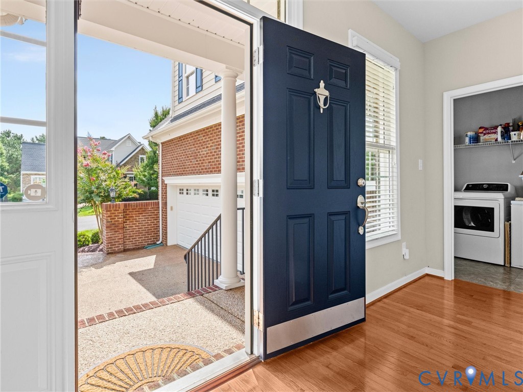 Wood-finish flooring with a contrasting dark paneled door and metal kick plate