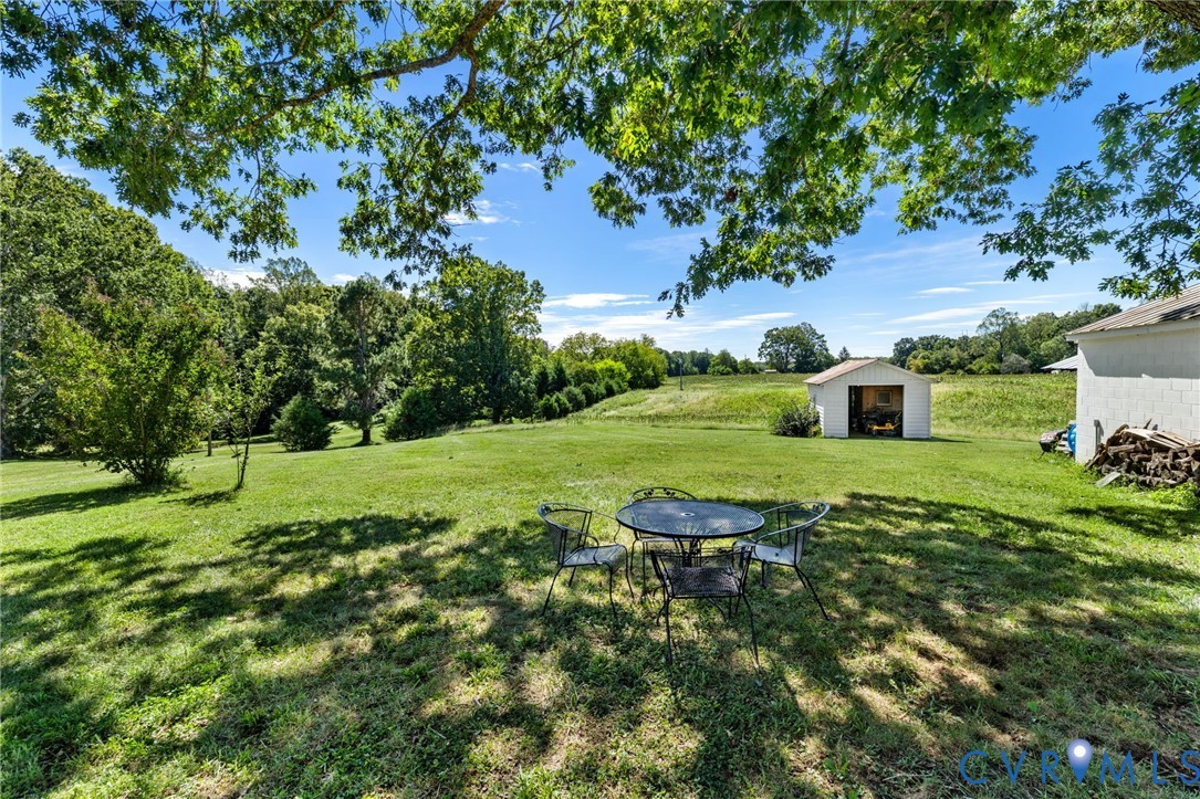 Expansive green lawn with mature trees and a detached shed
