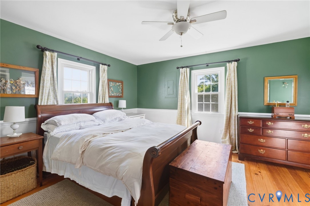 Hardwood flooring, painted walls, white trim, ceiling fan, and window
