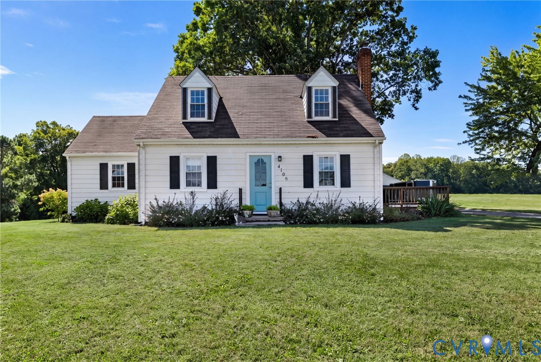 White exterior with black shutters and a light blue entry door