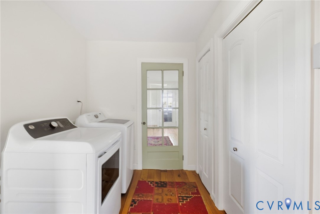 Hardwood flooring, painted interior door with glass panes, white paneled doors, and white walls