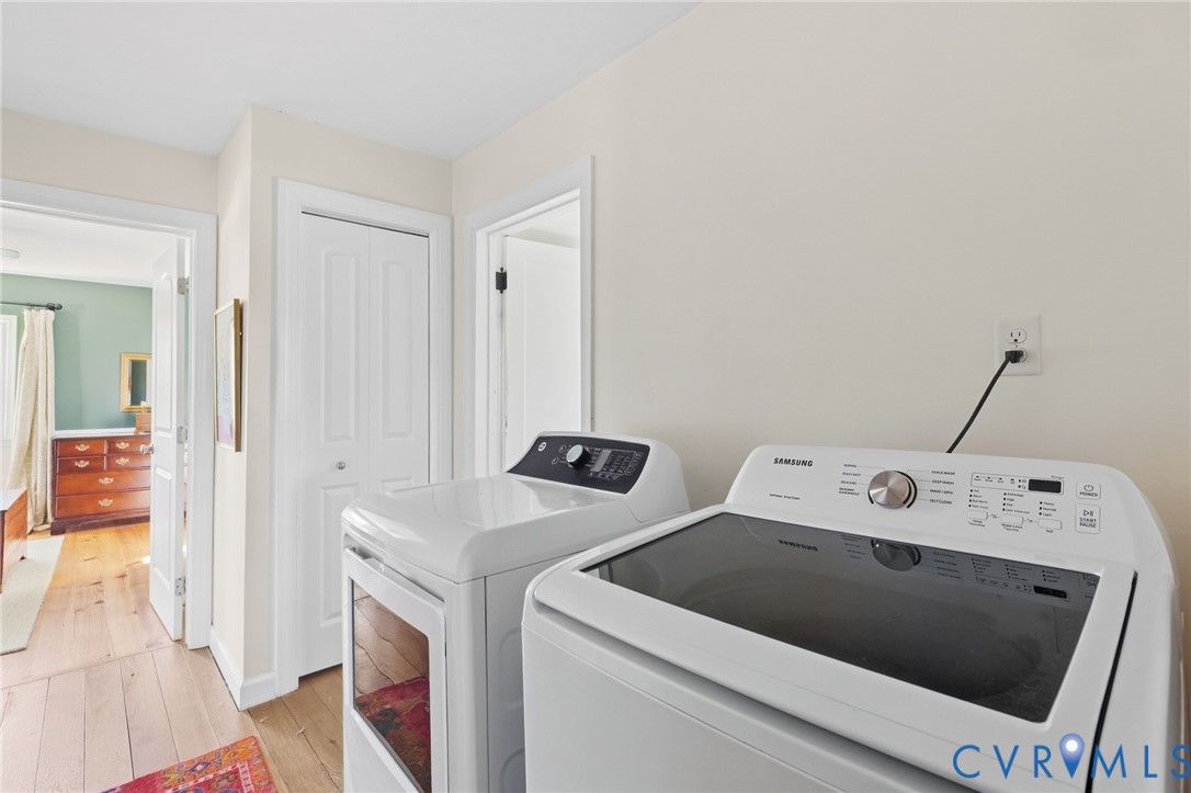 Laundry area with wood-finish flooring and bi-fold closet doors