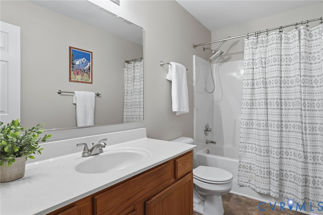 Full bathroom featuring a single vanity with a white countertop and wood-finish cabinetry