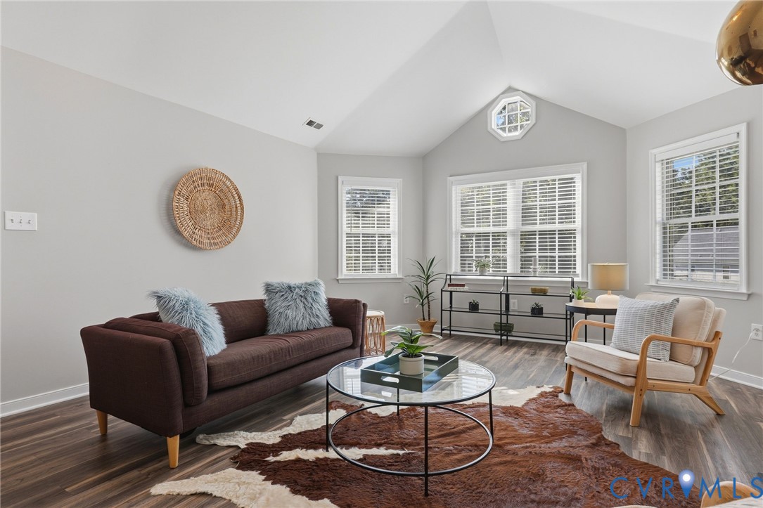 Vaulted ceiling with an octagonal window, wood-finish flooring, multiple windows with blinds, and light-toned walls Vaulted ceiling with an octagonal window, wood-finish flooring, multiple windows with blinds, and light-toned walls