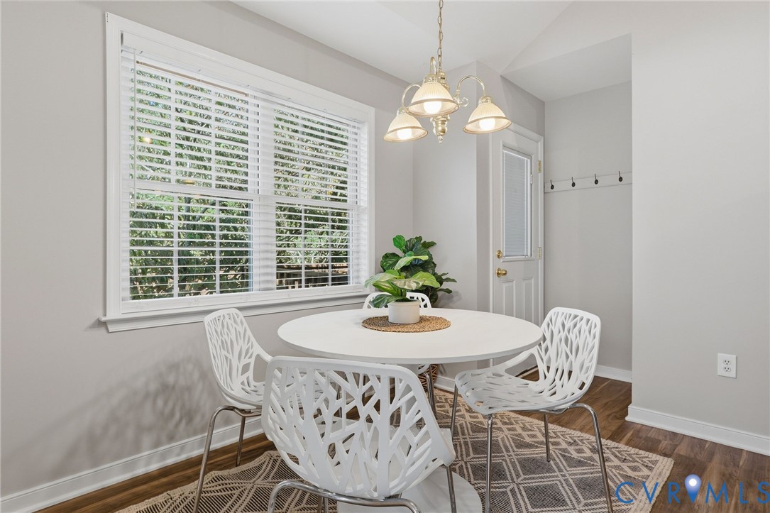 Wood-finish flooring, white window blinds, white trim, recessed lighting, and a hanging light fixture
