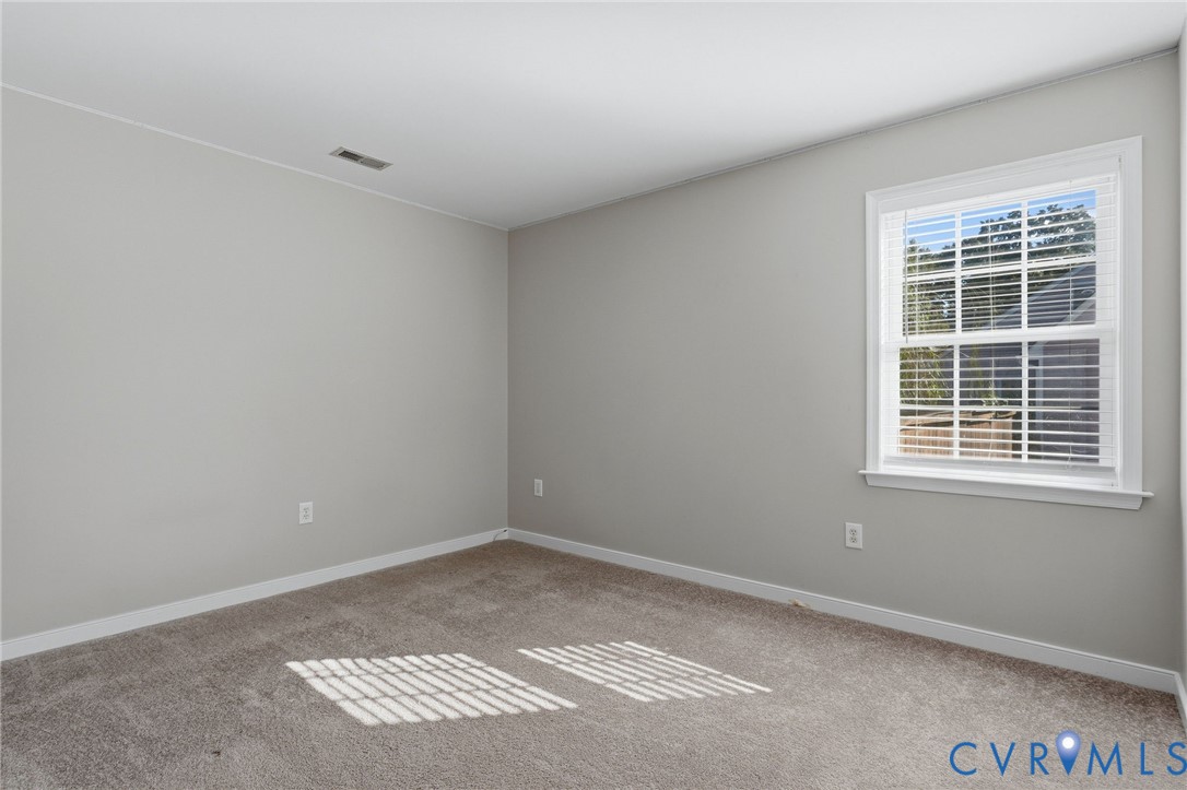 Carpeted flooring, white trim, and a window with blinds