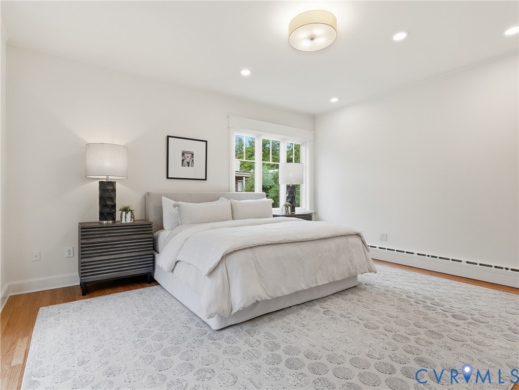 Hardwood flooring, recessed ceiling lighting, a flush mount ceiling fixture, and a large window