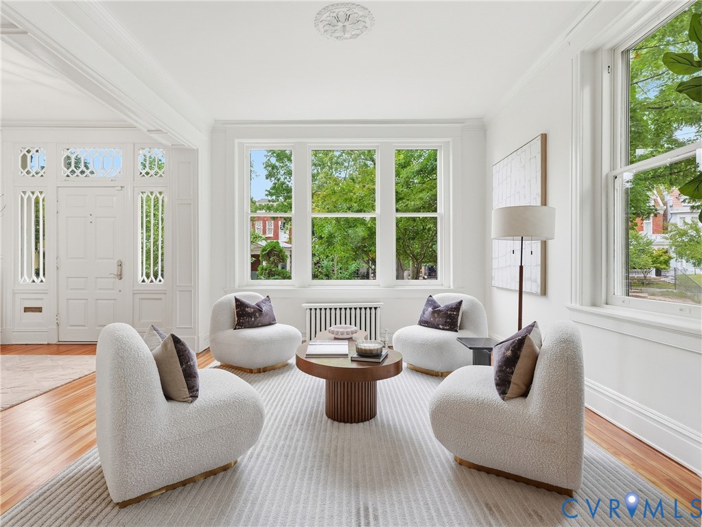 Expansive multi-pane windows, wood-finish flooring, ornate ceiling medallion, decorative door sidelights, and detailed crown molding Expansive multi-pane windows, wood-finish flooring, ornate ceiling medallion, decorative door sidelights, and detailed crown molding