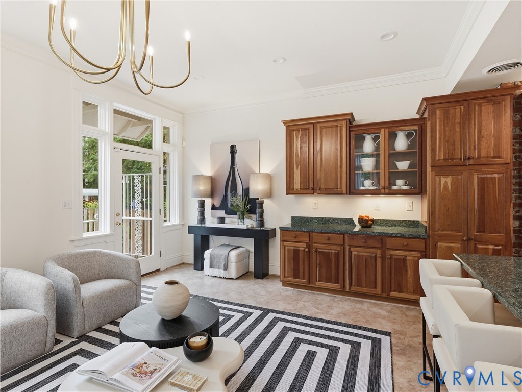 Recessed lighting, crown molding, double French doors, wood cabinetry, and green countertops