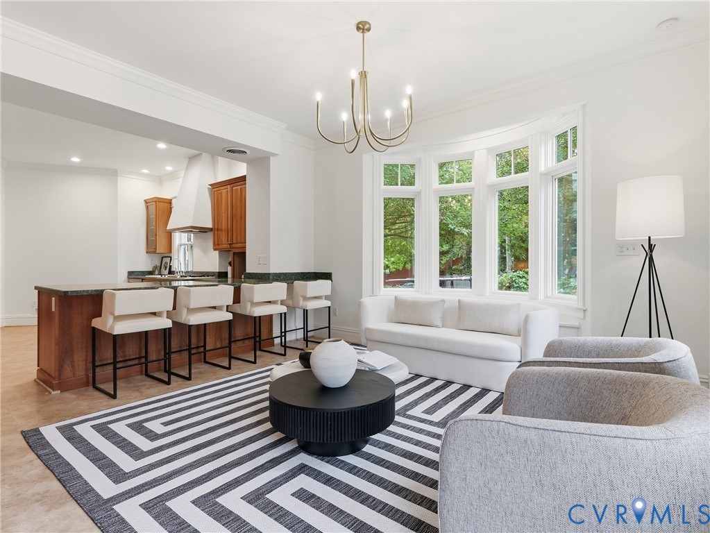 Recessed lighting, wood-finish flooring, a kitchen island with seating, upper and lower wood cabinetry, and a large bay window