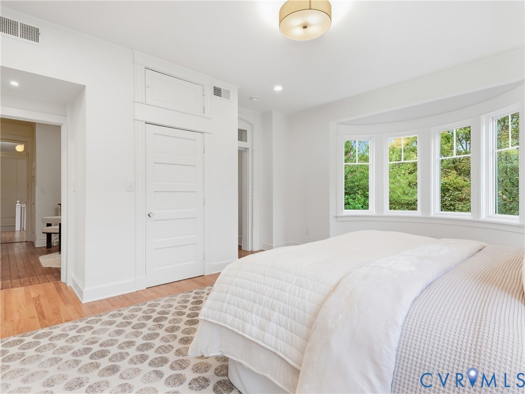 Hardwood flooring, recessed lighting, and a bay window