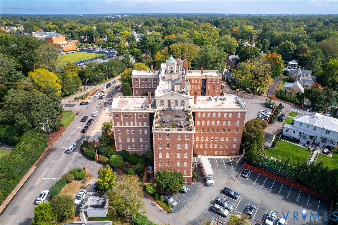 Multi-story brick exterior featuring a cupola, a rooftop terrace, and a paved parking lot