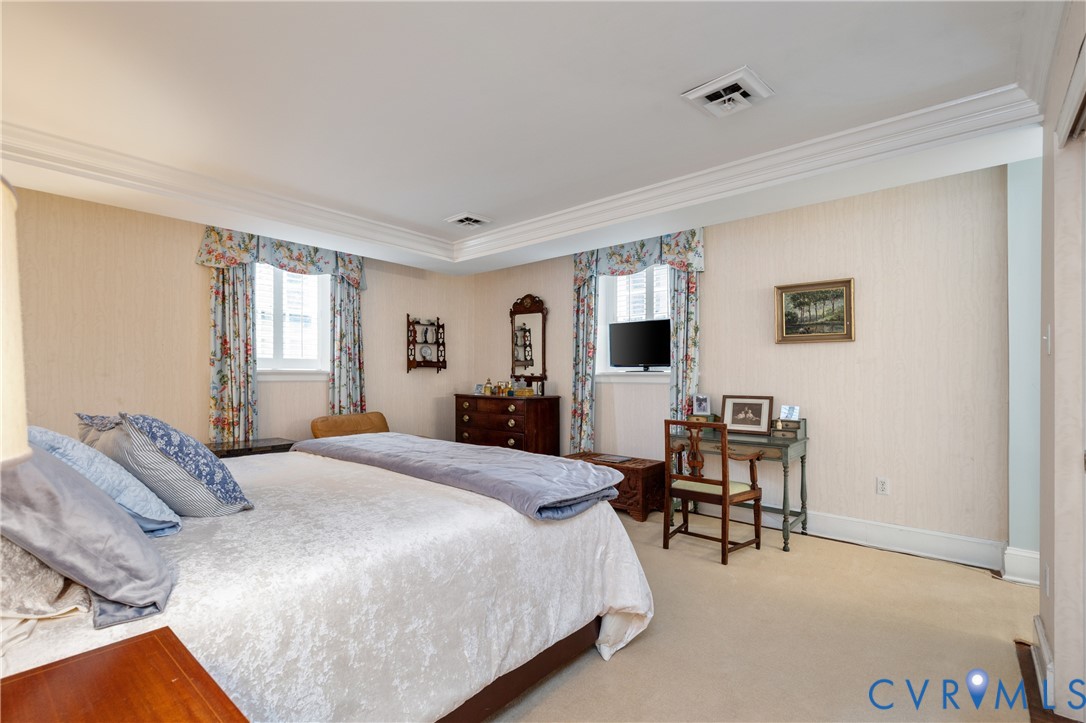 Room featuring neutral wall covering, multi-tiered crown molding, recessed lighting, and dual windows