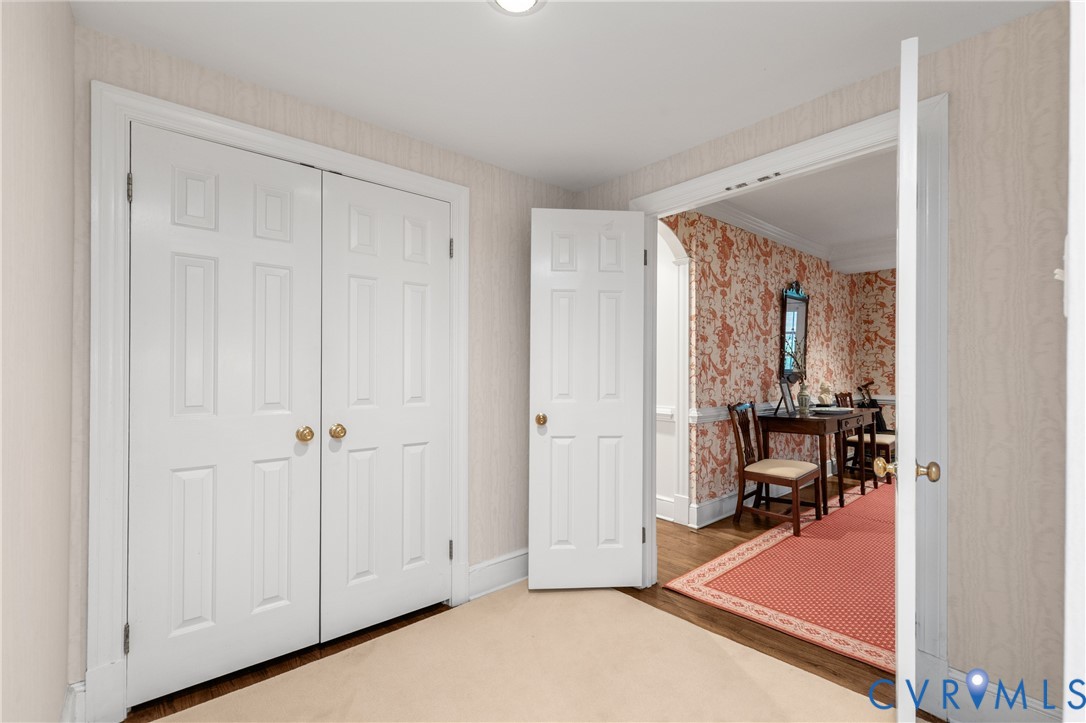 Neutral-toned textured wallpaper, white six-panel interior doors, and crown molding