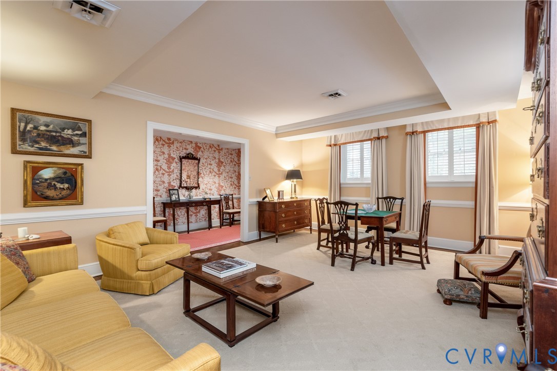 Tray ceiling, crown molding, chair rail molding, and windowed wall with recessed lighting